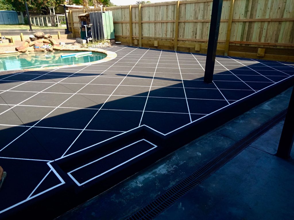 Decorative concrete pool surround with dark finish
